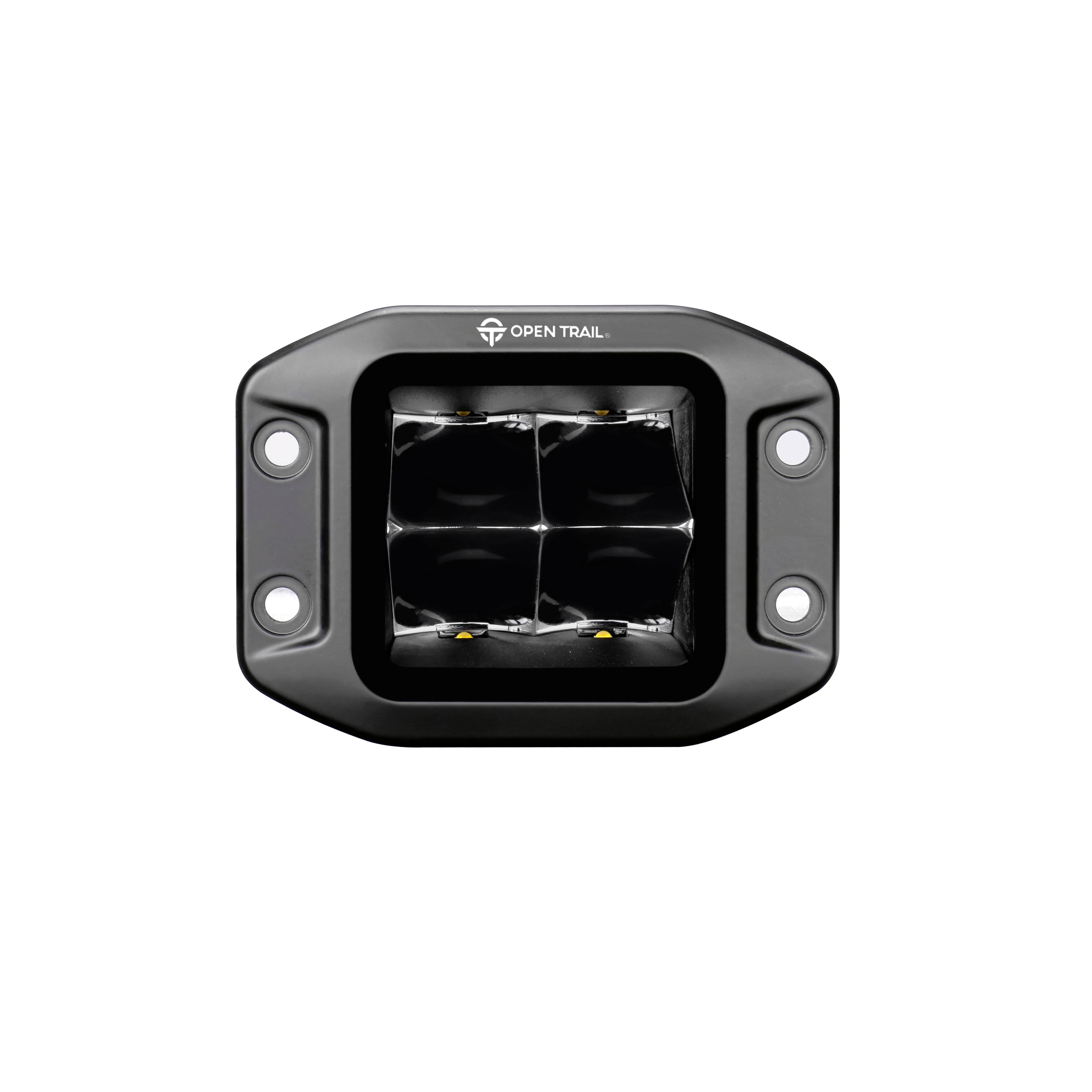 The Stealth LED Flush Mount Pods Spot by Open Trail is a black, rectangular light with four high-intensity LEDs in a rugged aluminum housing labeled OPEN TRAIL and features two mounting holes per side.