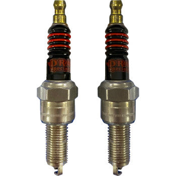 Two Drag Specialties Spark Plugs with hexagonal bases, black ceramic insulation rings, and brass-colored copper core terminals stand upright on a white background.