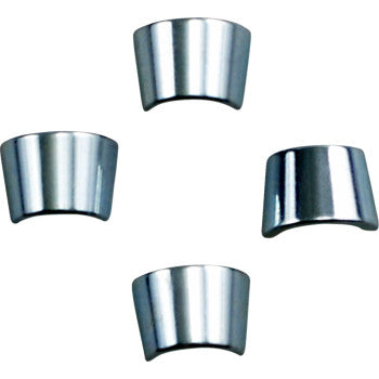 Four shiny, curved metal pieces—Xceldyne Valve Locks made from CNC-machined 8620 steel—are arranged in a diamond pattern on a white background.