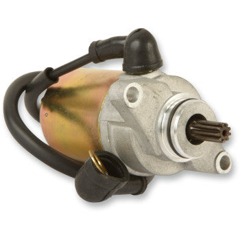 A close-up of the Starter Motor by Parts Unlimited shows its cylindrical metal body, attached wiring, visible end gear, black rubber connectors, and durable copper bushings built to OEM specs for smooth operation.