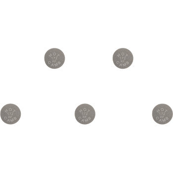 Set of five small, round metallic valve shims with etched size markings on each piece.