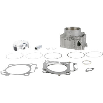 High-compression Honda cylinder kit with silver piston, gray cylinder block, and multiple gaskets and rings laid out on.