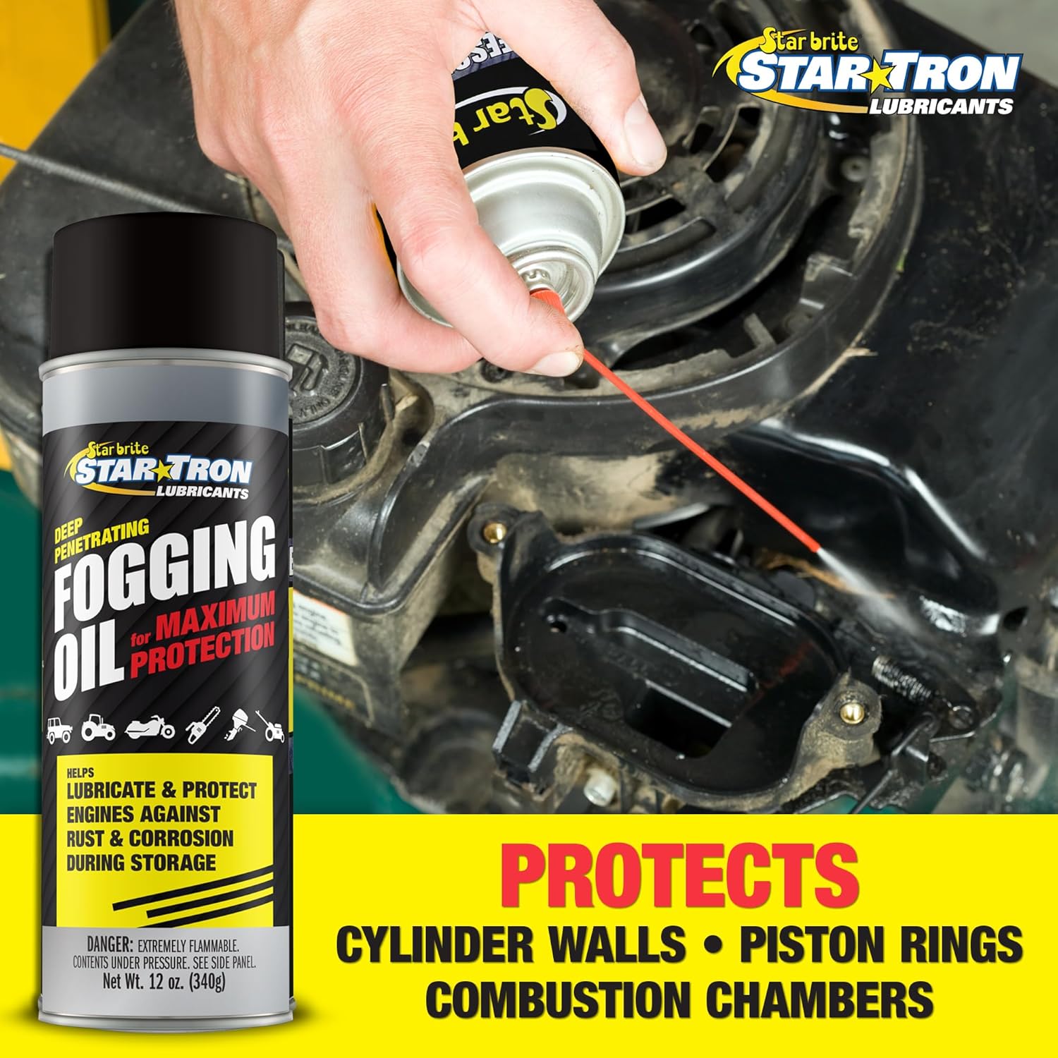 A hand sprays Star Tron Fogging Oil into an engine with a red straw nozzle, perfect for winterizing motorcycle engines. The can warns it lubricates and protects cylinder walls, piston rings, and chambers against rust during storage.