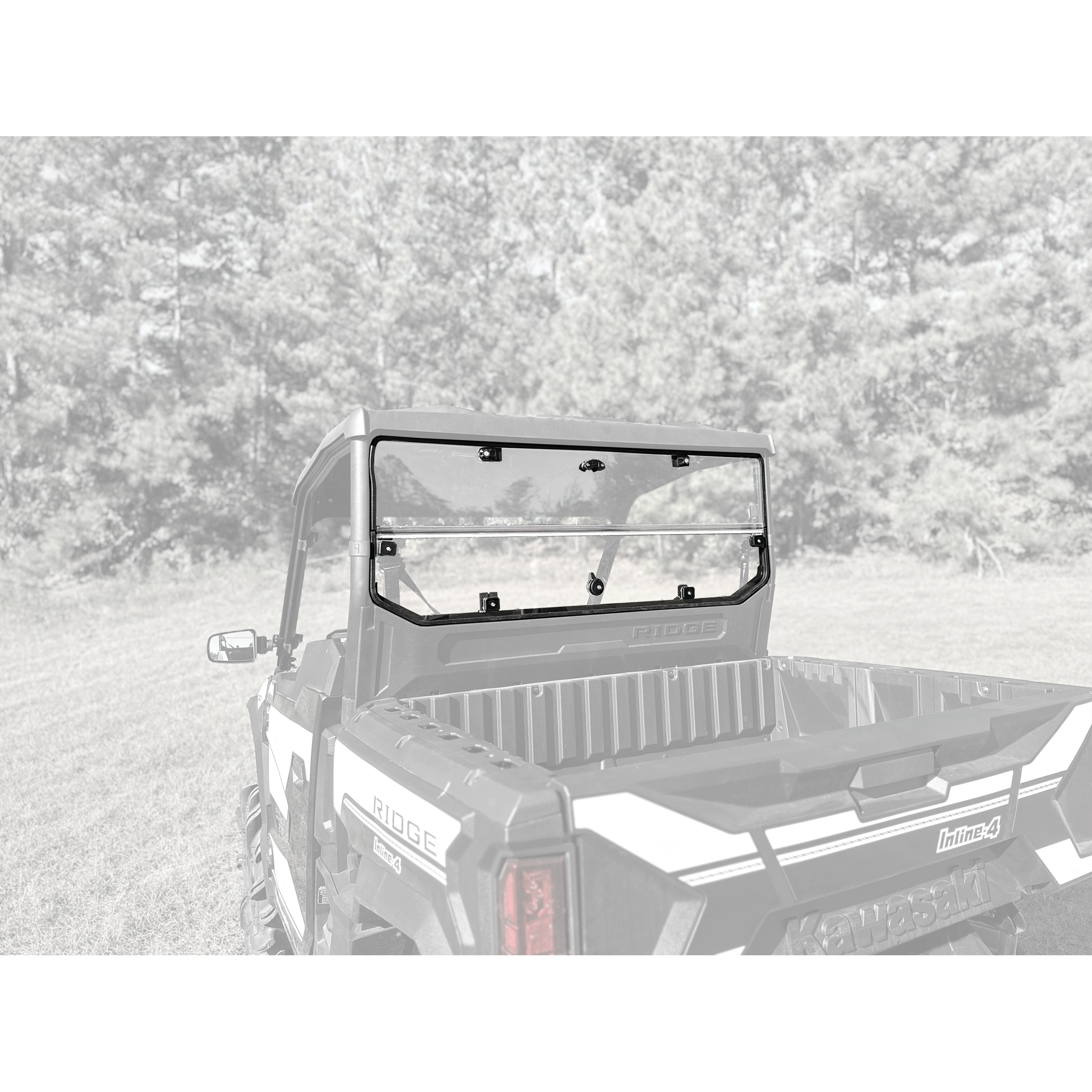 A Can-Am utility vehicle featuring a Seizmik Composit Roof is parked on grass, with trees blurred in the background. The vehicle has an open cargo bed and a heavy-duty plastic rear window, shown from behind at an angle.