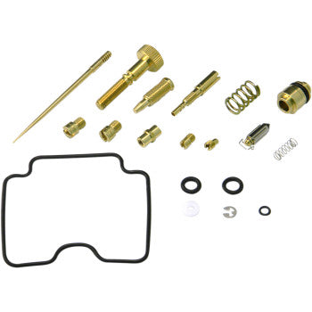 Brass carburetor repair parts including jets, needles, springs, O-rings, and a large black rubber gasket arranged on a white
