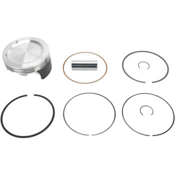 Silver metal piston with black grooves, cylindrical pin, and five circular black piston rings of varying thicknesses.