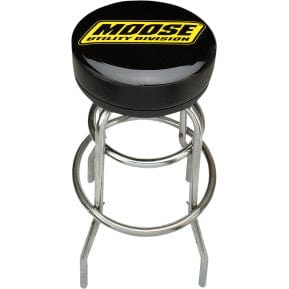 The Stool Bar Utility by Moose Utility features a chrome-plated frame, round black cushioned seat with yellow MOOSE UTILITY DIVISION text, four sturdy legs, and a circular footrest for added comfort.