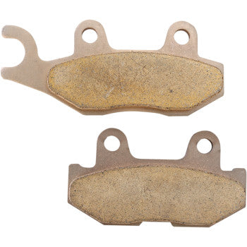 Two Yamaha Standard Brake Pads by DP Brakes with mounting holes are shown from different angles. They feature bronze-colored backing plates and textured friction surfaces—ideal as ATV brake pads.