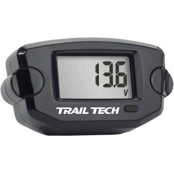 The Voltage Meter Black by Trail Tech is a digital battery monitor with a black casing, 13.6V display, and one lower right button. TRAIL TECH appears below the screen, ensuring reliable voltage readings.