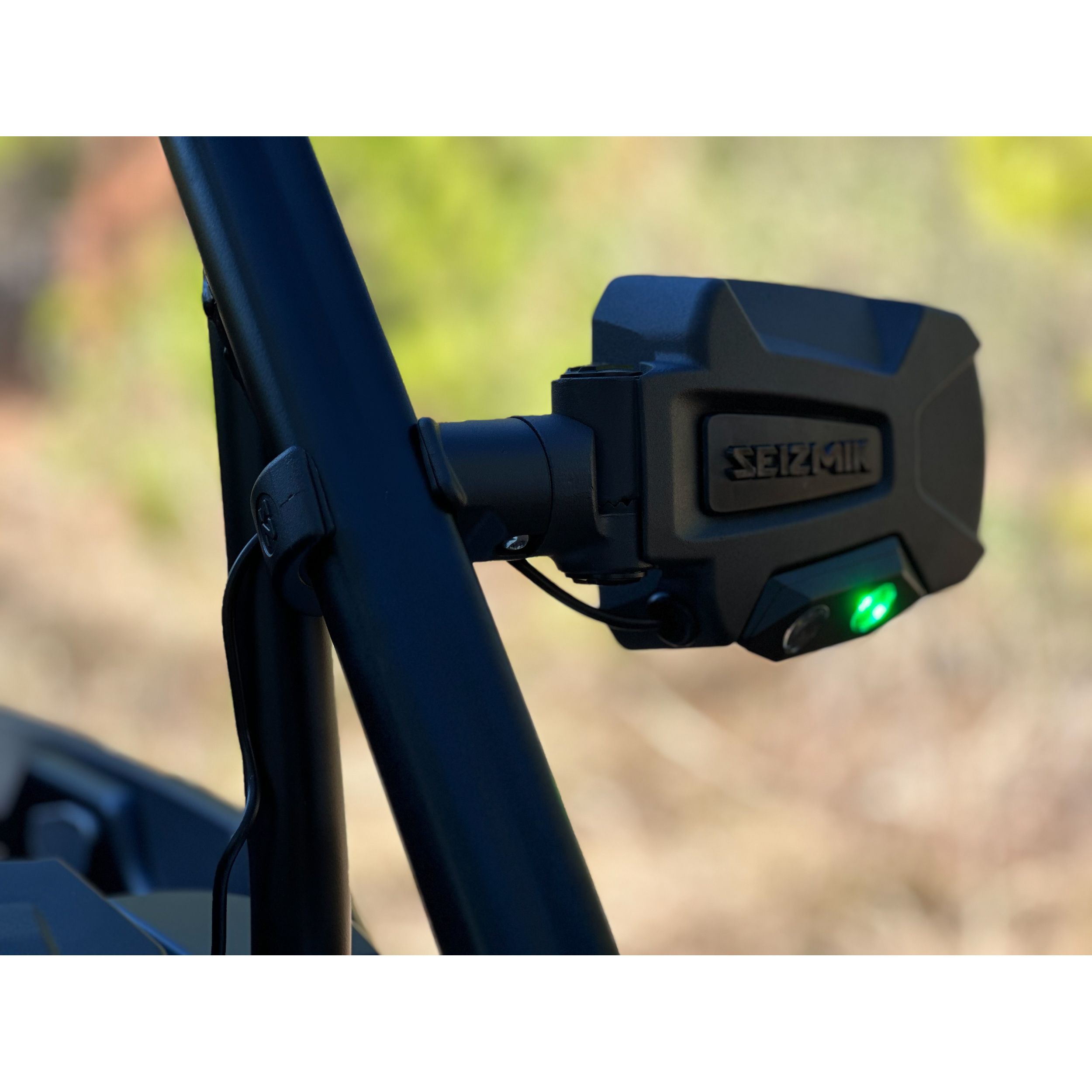 Black rectangular Seizmik Trailrider side mirror with integrated green LED indicator mounted on metal arm and roll cage.