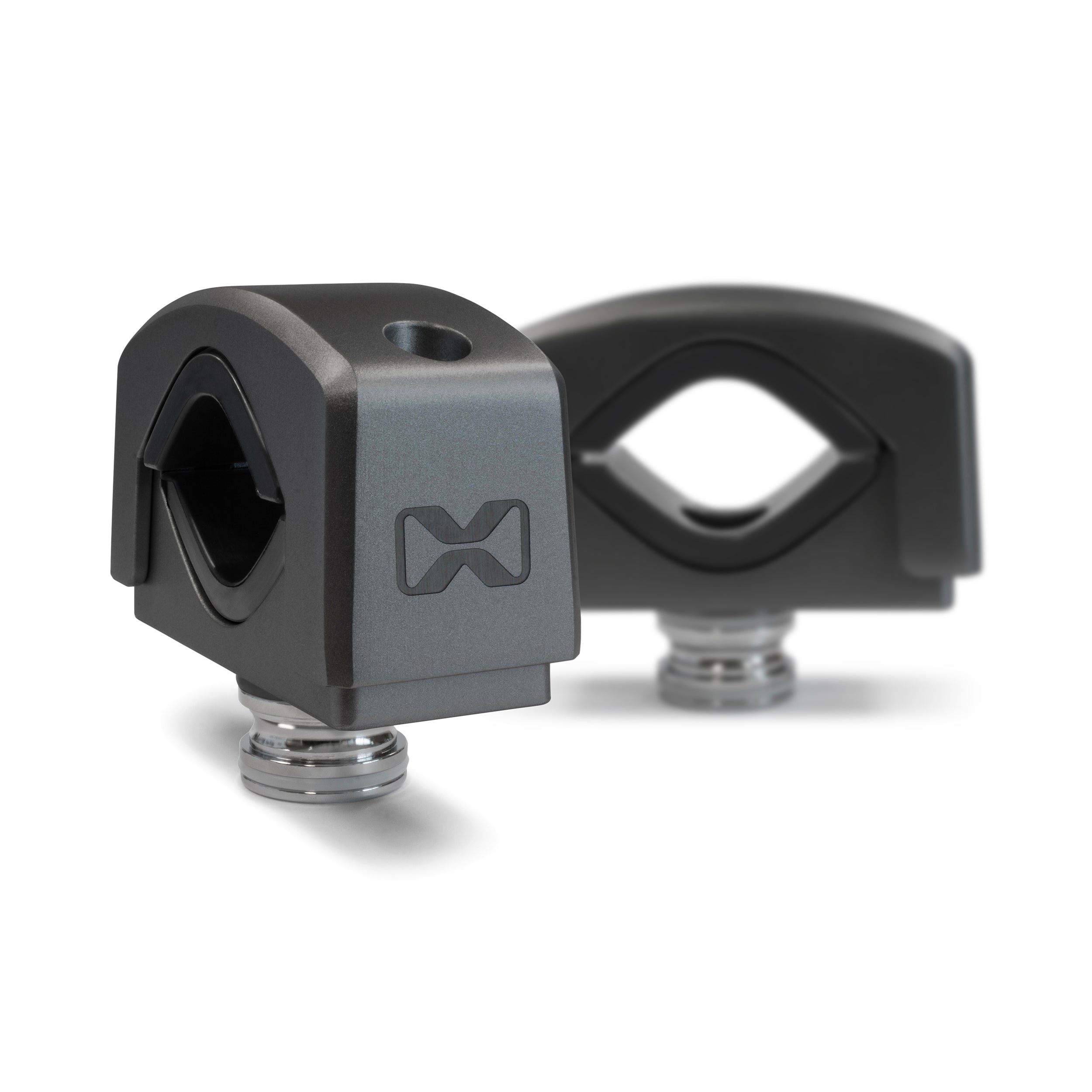 Two black, angular metal Tower Speaker Mounts by EcoXGear with a stylized “M” logo, threaded silver bases, and a hole on top are displayed on a white background. One mount is in focus in front; the other appears slightly blurred behind.