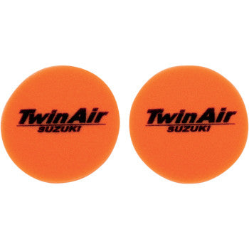 The Suzuki Standard Air Filter by Twin Air includes two round orange foam covers, each printed with Twin Air SUZUKI in black, designed to enhance air filter performance.