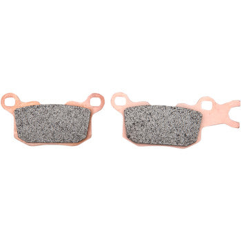 Two SXR Brake Pads by EBC with textured friction surfaces, copper-colored backing plates, and uniquely shaped mounting tabs are displayed side by side on a white background.