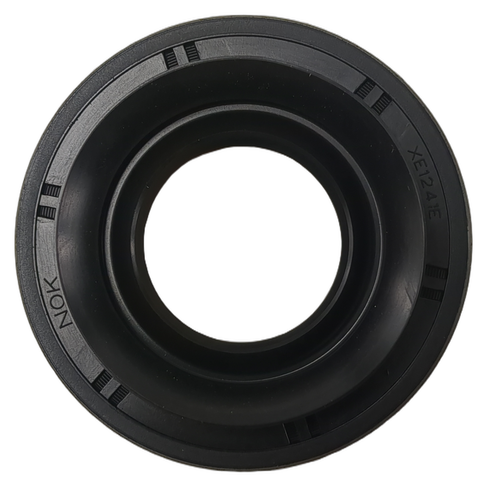 Black rubber oil seal with smooth inner ring and grooved outer edge embossed with "NOK" and "XC734E".