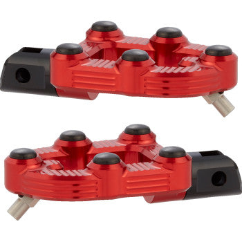 Two red, metallic MX Footpegs - Driver by Arlen Ness, each with black and silver details, four raised black pads, and a silver pin on one end, are displayed against a white background.