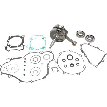Metal crankshaft assembly with multiple round gaskets and seals laid out on white background.
