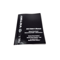 A black 2012 Owner’s Manual for Cross Roads and Cross Country motorcycles by Polaris is placed on a white surface. The cover displays the Victory logo, making it an essential reference for Victory motorcycle OEM parts.
