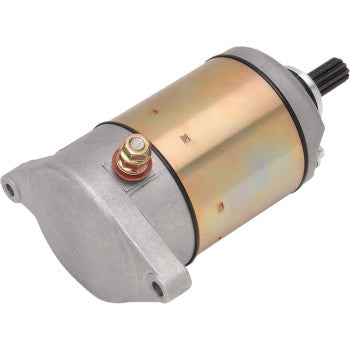 The Suzuki Starter Motor by Ricks Motorsport Electric is a metallic cylindrical aftermarket starter with a gold and silver finish, protruding gear, longer-life bearings, and red/gold terminal bolt on the side.