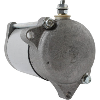 A close-up of the Starter Motor by Parts Unlimited, featuring a cylindrical metal body, copper bushings, mounting bolts, and a top terminal post—engineered to meet OEM specifications.