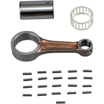 The Yamaha Connecting Rod Kit by Prox, featuring a metal connecting rod with big and small ends, a cylindrical spacer, a white roller bearing, and several small metal rollers, is arranged on a white background.