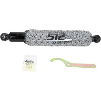 Black metal 512 Series rear shock with gray protective cover and included adjustment wrench and instruction sheet.