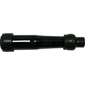 A black cylindrical electronic component, the Spark Plug Resistor Cover by Moose Offroad, labeled K&S 10-2121 5-KΩ, has capped ends—possibly waterproof—and a central body similar to ceramic resistors or coils.