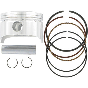 Polished silver cylindrical piston with wrist pin, two circlips, and four black piston rings with copper highlights.
