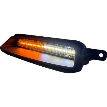 Close-up of the Fairing Vent Light - LED - Black by Custom Dynamics, showing its illuminated amber strip and reflective housing in a black casing with a mounting hole, similar to motorcycle turn signal or fairing vent light designs.