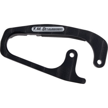 The Honda Front Chain Slider Black by T.M. Designworks features a curved shape, mounting hole, and white/gray logo on top. Made from durable composite materials for extended wear life.