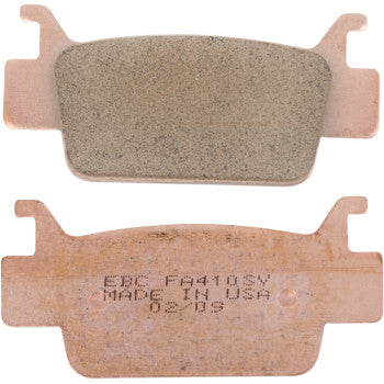 Two copper-colored SV Severe Duty Brake Pads by Ebc are shown—one with a smooth friction surface, the other displaying backing stamped “EBC FA410SV MADE IN USA.” These brake pads offer high durability and consistent performance.