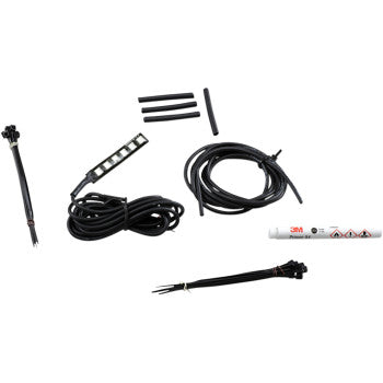 A set of automotive wiring components, including black cables, connectors, heat shrink tubes, a white adhesive tube, and the War Bonnet Accent Light by Custom Dynamics with color-changing LEDs, arranged on a white background.