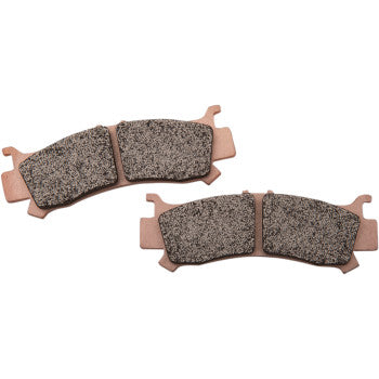 Pair of gray textured brake pads with copper-colored metal backing, curved shape with tabs.