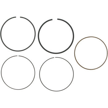 Five rings from the Ring Set by Wiseco are shown on a white background: four black metal rings with gaps and one brown ring with a textured surface.