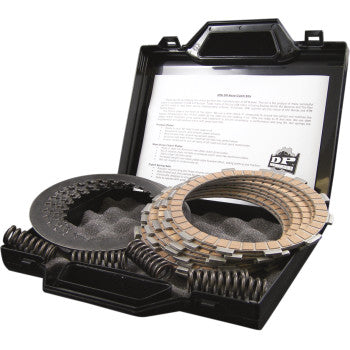 An open black case displays the Yamaha Clutch Kit by Dp Brakes, featuring steel drive plates, friction plates, and springs arranged on foam padding. An instruction sheet is visible inside the lid.