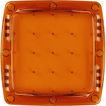 The Light Cover Q Series Amber by Rigid Industries is a square, translucent orange polycarbonate tray with a raised rim, small round indentations on the base, and alternating translucent and white rectangular side patterns for added protection.