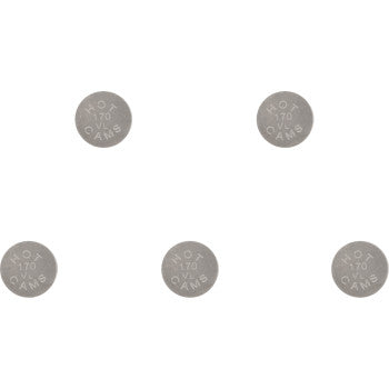 Five round silver metal valve shims engraved with size markings, arranged in a scattered pattern.