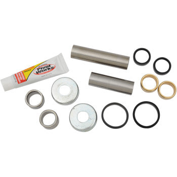 The Swingarm Bearing Kit by Pivot Works includes a tube of lubricant, two metal rods, four metal washers, two brass bushings, and four rubber O-rings—perfect for suspension control maintenance.