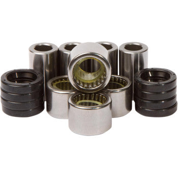 A set of cylindrical needle roller bearings from the Linkage Rebuild Kit by Pivot Works, shown in metallic silver and black and arranged in an overlapping row on a white background for suspension control and shock bearing use.