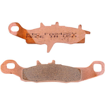 Two SV Severe Duty Brake Pads by Ebc are shown: one with "MADE IN USA" engraved, the other displays the friction side. Both feature mounting holes and are designed to minimize rotor galling in muddy or sandy conditions.