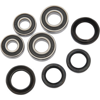 The Honda TRX Wheel Bearing Kit Front by Pivot Works includes seven circular double-sealed ball bearings and three black rubber seals, all featuring metal outer rings with visible inner circles, arranged on a white background.