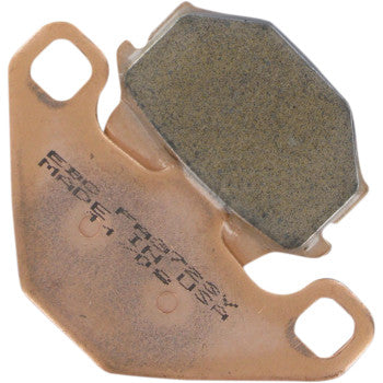 Copper-colored metal brake pad backing with a textured, dark friction surface and two mounting holes.