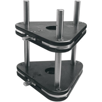 The Crankshaft Assembly Fixture by K&L Supply is a triangular metal mold with two black plates joined by three vertical silver rods, creating a stacked open structure featuring holes in the plates.