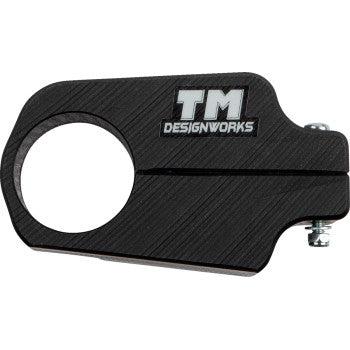 The Yamaha Front Chain Slider Black by T.M. Designworks is a durable composite clamp with a large circular opening, slotted screw fastener, and engraved logo—engineered to extend wear life on ATV front chain assemblies.