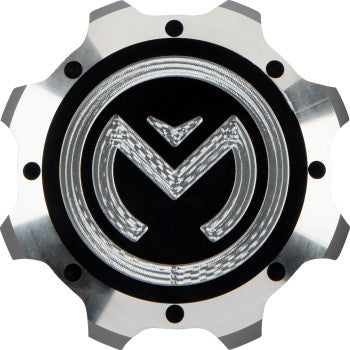 The Can Am Gas Cap Silver Black by Moose Offroad is a CNC-machined aluminum cap with a metallic finish, featuring a black background, silver gear-like edges, and an engraved M logo with an arrow design in the center.