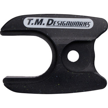 The Yamaha Raptor Front Chain Slider Black by T.M. Designworks is a black composite chain slider with a curved opening, circular hole, and gray T.M. DESIGNWORKS label, made for extended wear life.