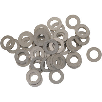 Metallic silver flat circular drain plug washers with a central hole, arranged loosely.