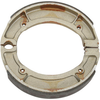 The Yamaha 9152 Brake Shoes by DP Brakes are circular, metallic pads with four bolt holes and minor rust spots, designed for drum brake systems to provide durable, fade-free braking performance.