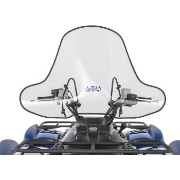 A Big Country Windshield 20 3/4 Xtreme Low by Slipstreamer is mounted on the handlebars of a blue ATV, offering wind protection while keeping the vehicle’s controls and mirrors visible behind its quick-release polycarbonate shield.