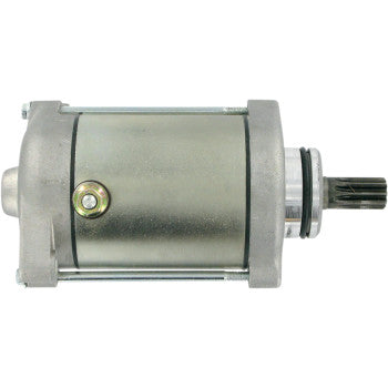 Silver cylindrical Suzuki starter motor with a metal casing and a black gear shaft on one end.
