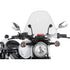 Front view of a motorcycle with a large clear Spitfire Windshield - 15 by Slipstreamer, round headlight, two side mirrors, and turn signals mounted on each side of the handlebars.